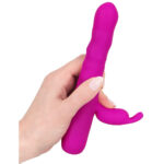 XOUXOU perle og rabbit vibrator i blød silikone og vandtæt overflade. En perle og rabbit vibrator af silkeblødt silikone der kan tages med i badet og giver roterende fornøjelse og stimulering til klitoris. Den lækre bløde vibrator er overtrukket med medicinsk silikone der er utrolig hudvenlig. Det er specielt godt for dem der har problemer med allergier. Indvendig slår der et kraftigt hjerne der med sine 2 motorer sørger for utrolig stimulerende rotation og vibration. Den styres legende let via knapperne i bunden. Du kan vælge mellem 4 programmer samt højre/venstre rotation. Batterierne er genopladelige og oplades via det medfølgende USB kabel.  De roterende perler der gemmer sig under den bløde silikone for sørger for en helt unik fornemmelse. De giver g-punktet en utrolig pirrende og intens forkælelse. Specielt hvis du tager den med i bad, og nyder den med dejlig varmt vand. Vibratoren er nemlig 100% vandtæt, hvilket også gør det meget nemmere at rengøre den.  Klitoris vibratoren der sidder på skaftet har sin egen motor og sørger for prikken over i'et. Den lægger sig ind over klitoris når vibratoren er ført ind og stimulerer med sine 2 små ører. Det hele i kombination giver en langt bedre og kraftigere orgasme.  Vi anbefaler at du smører lidt vandbaseret glidecreme på vibratoren inden den føres ind. Det gør den mere behagelig, naturlig og glidevenlig.  Roterende perler. Samlet længde: 18,3 cm. Penetrationsdybde: 11,2 cm. Diameter: 2,6 cm. Materiale består af silikone og PU (ftalatfri). 100% vandtæt så kan tages med i bad.  Genopladelige batterier der oplades via USB.